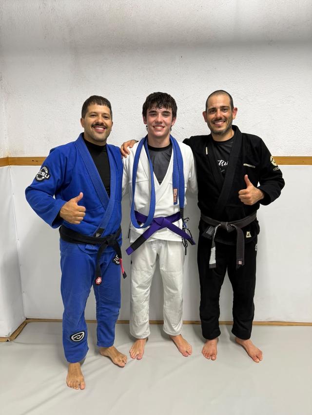 Gonçalo between his two black belt coaches on purple belt day